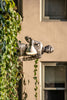 statue man holding light near building