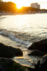 water waves hitting rocks during sunset