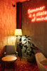 a room with a chair, table and a neon sign on the wall