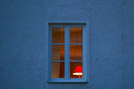 a red lamp sitting in a window next to a blue wall
