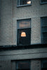 a brick building with a lamp in the window