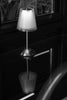 a lamp sitting on top of a table next to a window