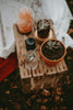 a wooden table topped with a potted plant next to a glass