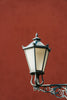 A street light with a red wall in the background