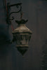 A lamp hanging from a wall in a dark room