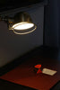 A desk with a lamp and a piece of paper on it