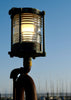 A lit nautical lamp against a clear sky.