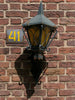 A decorative lamp is mounted on a brick wall.