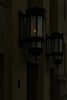Wall-mounted lanterns illuminate the dark building.