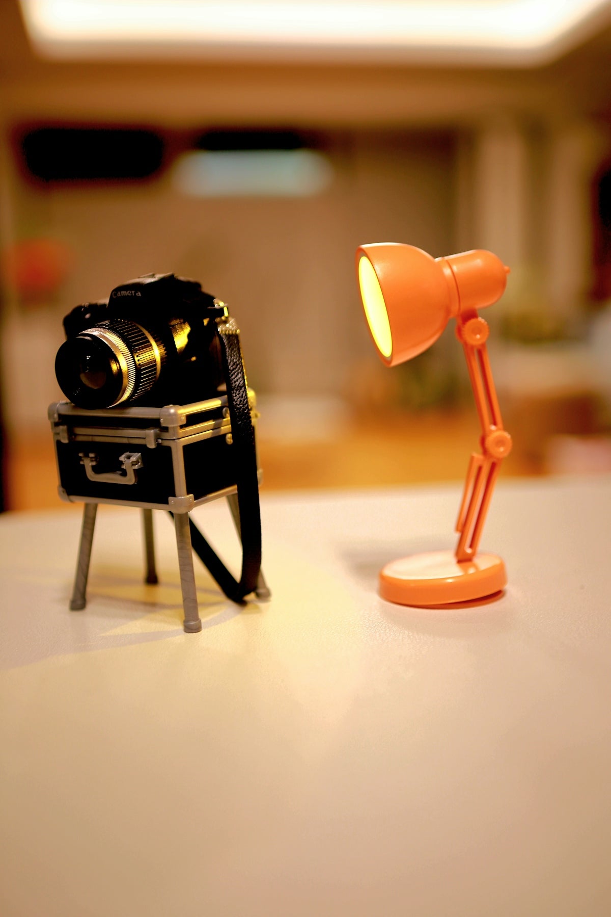 Camera and orange lamp on a table