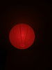 A red paper lantern glows in the dark.