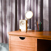 Desk with clock, lamp, and pens near pens