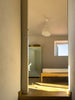 Sunlit hallway leading to a bedroom with a bed.
