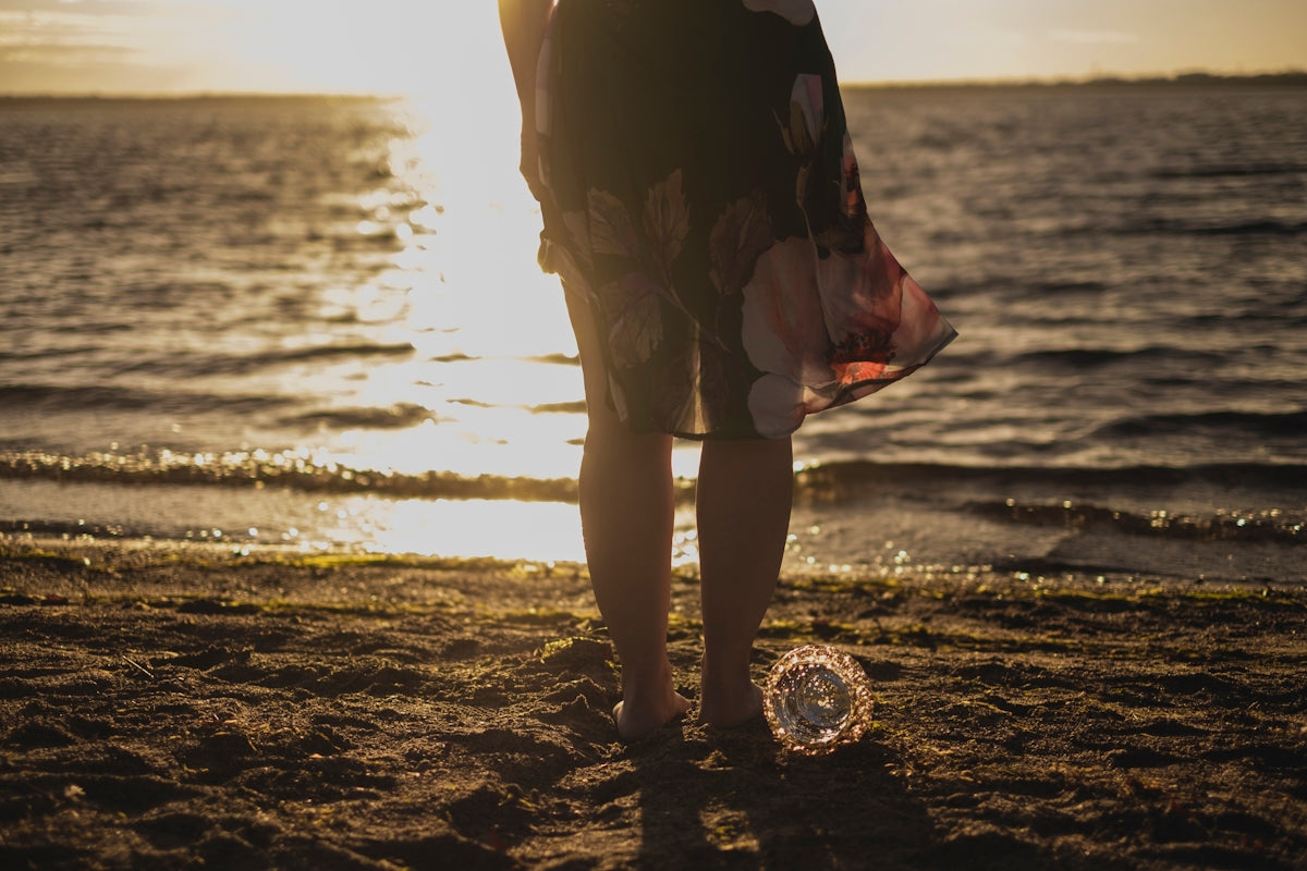 woman in black dress standing on beach during sunset
