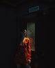 woman in red and white floral dress standing near door