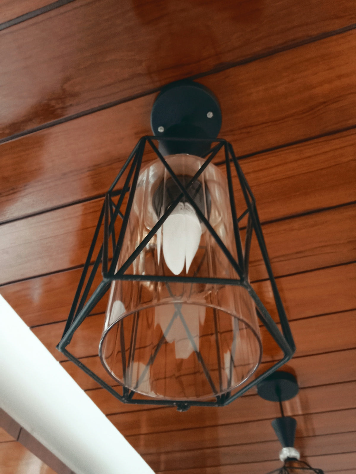 a light fixture hanging from a wooden ceiling