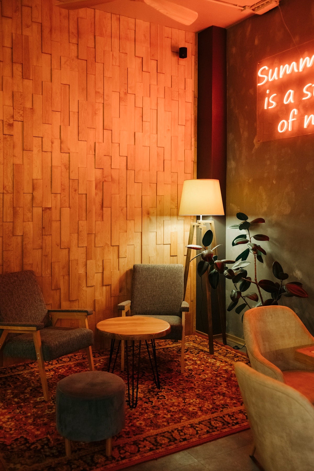 a living room filled with furniture and a neon sign