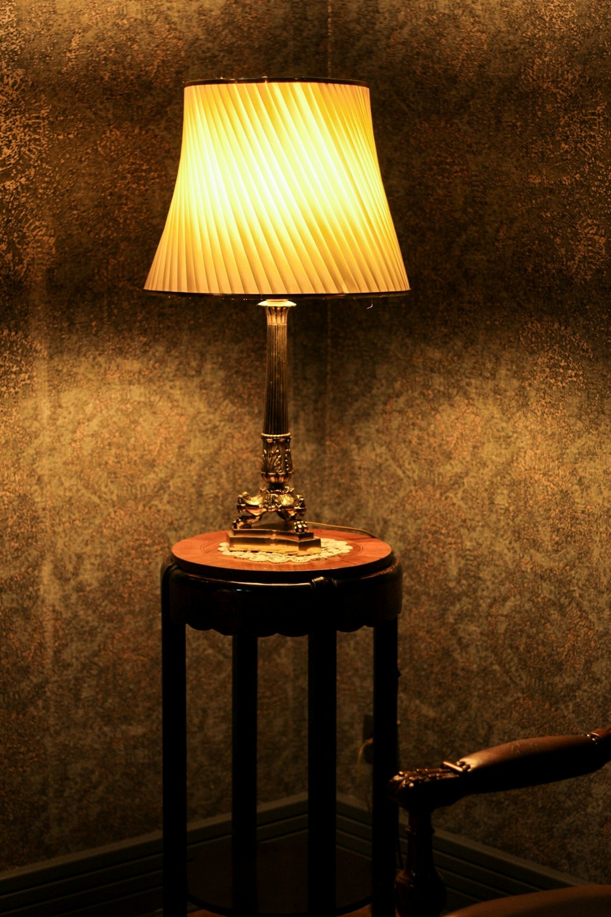 a lamp sitting on top of a table next to a chair