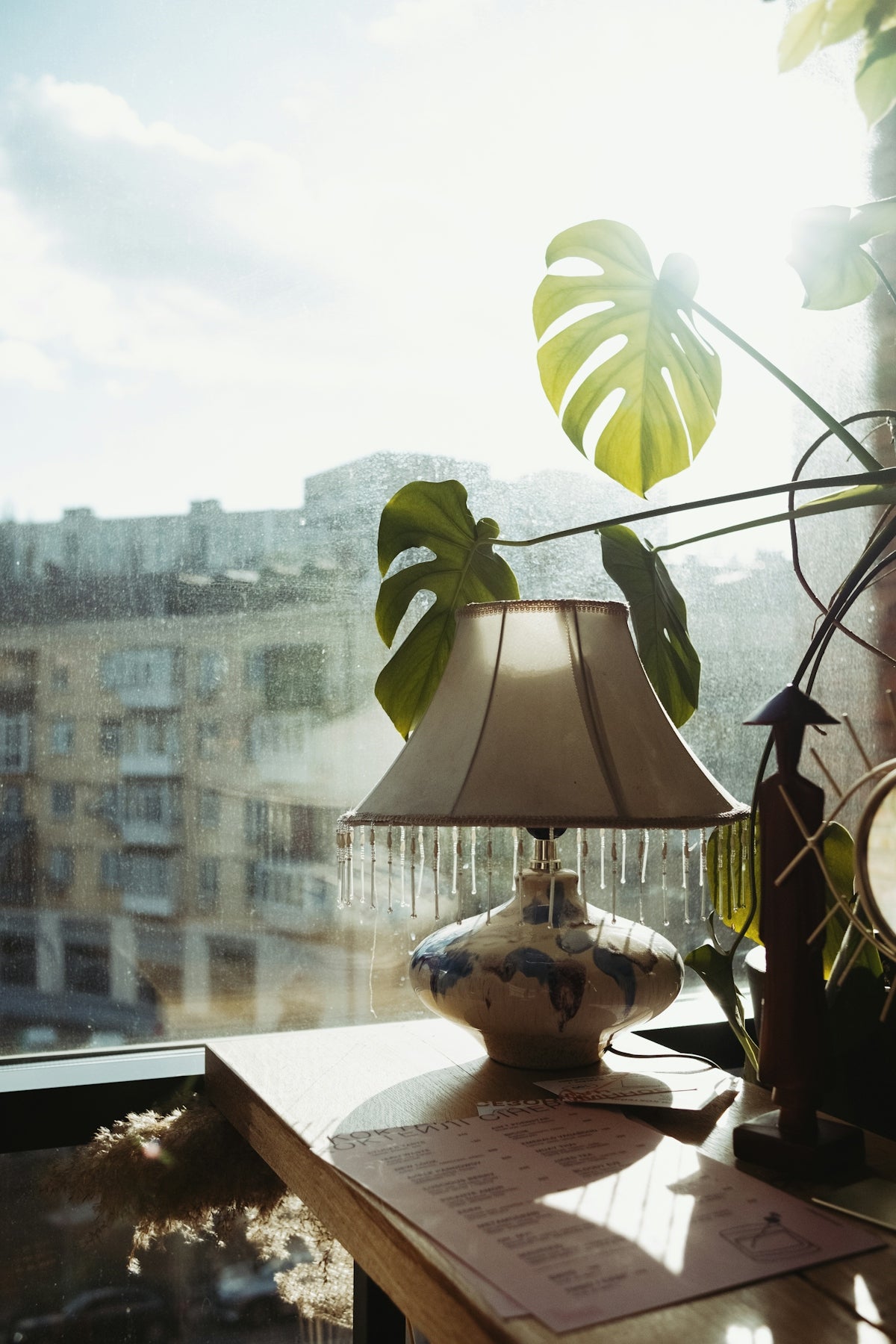 a lamp sitting on top of a table next to a window