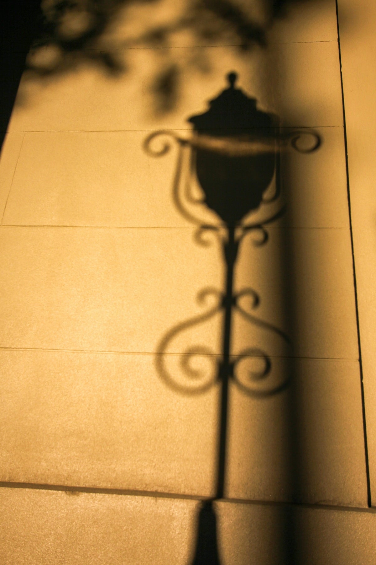 a shadow of a street light on a sidewalk