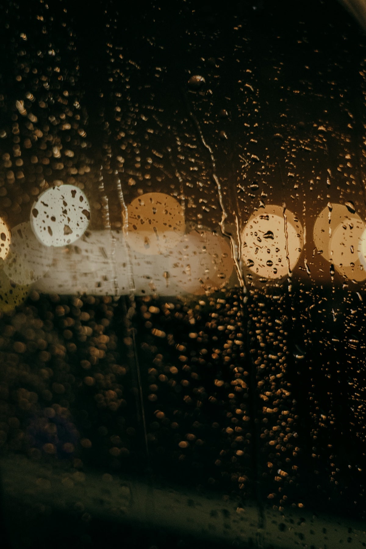 rain drops on a window with a street light in the background