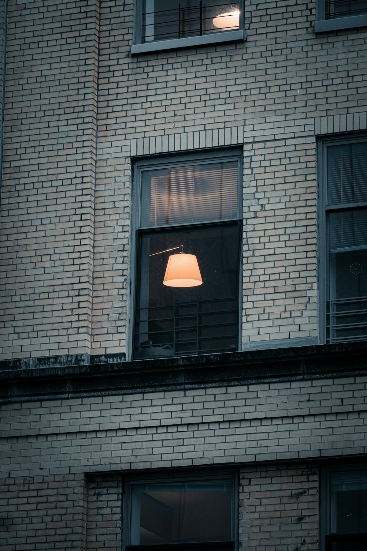 a brick building with a lamp in the window