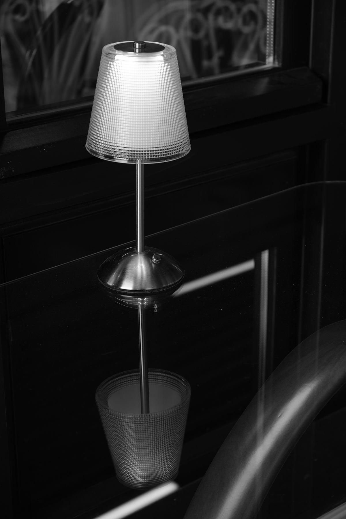 a lamp sitting on top of a table next to a window