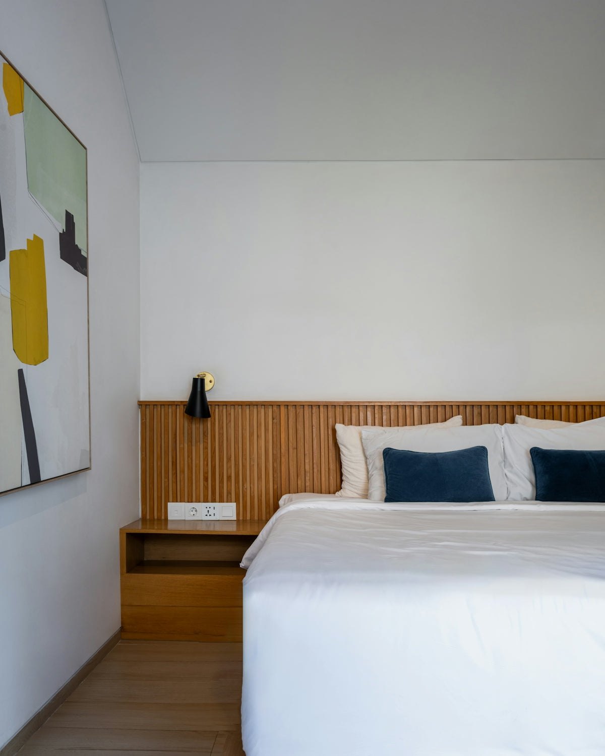 A bedroom with a bed and a painting on the wall