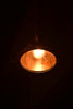A light hanging from a ceiling in a dark room
