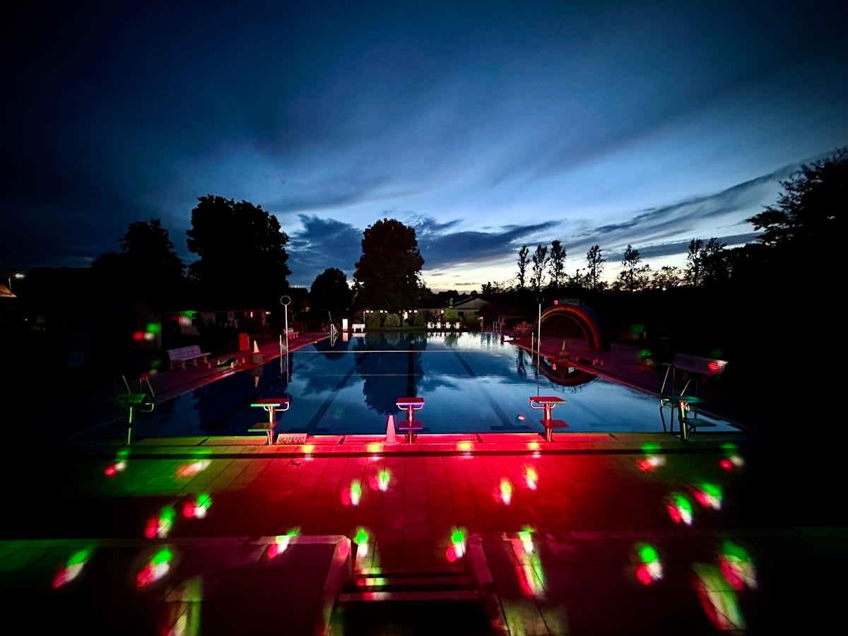 A pool with a lot of lights around it