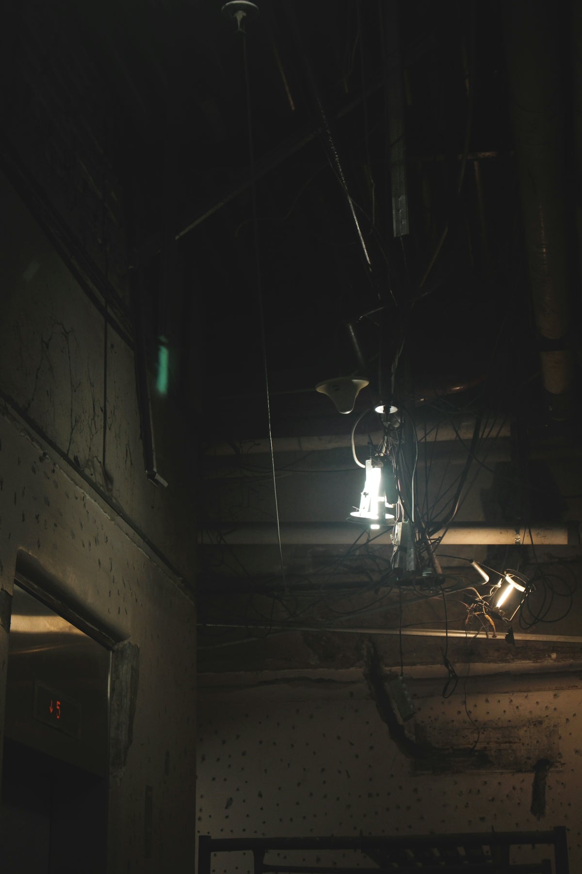 A dimly lit room with exposed pipes and lights