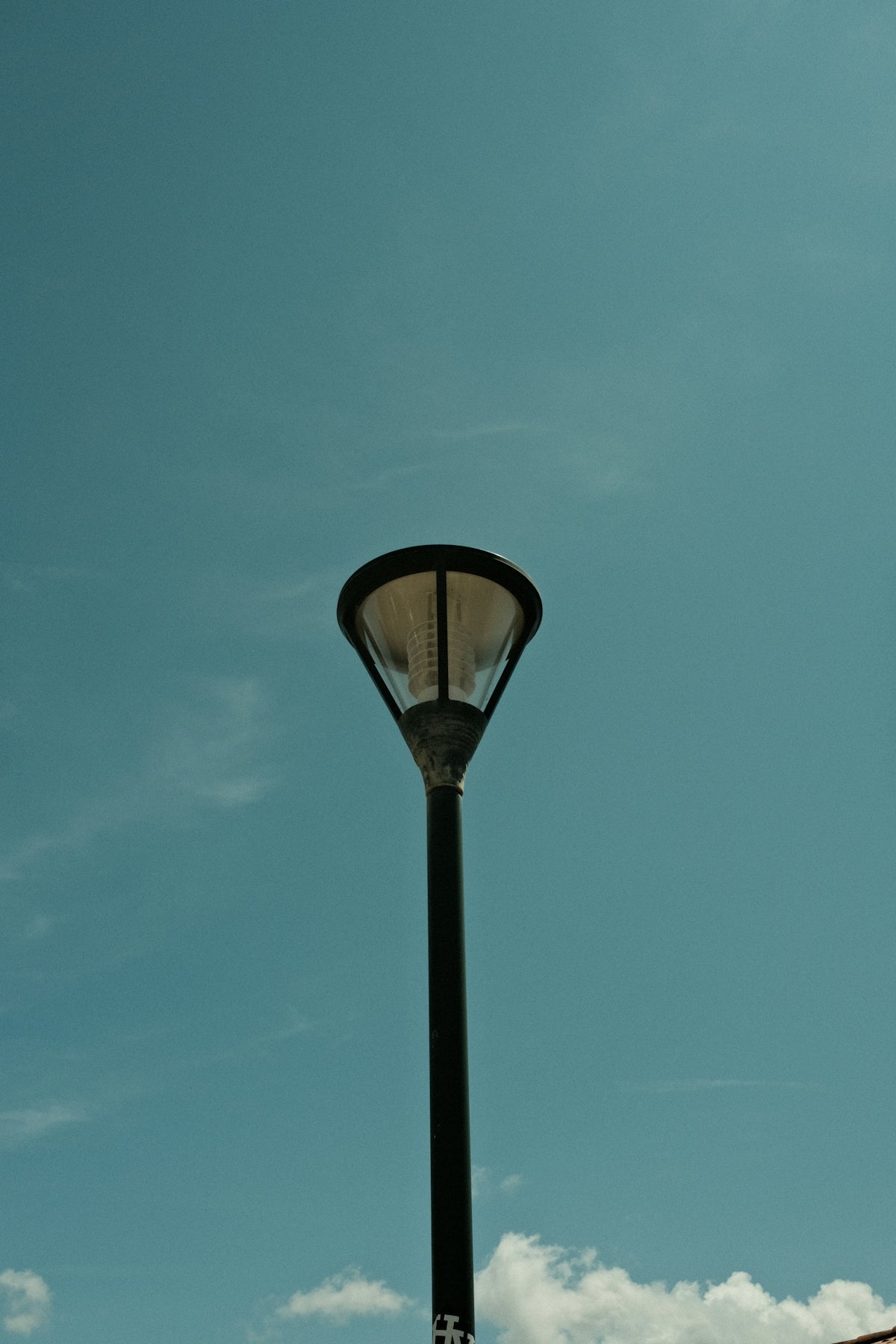 A street light with a clock tower in the background