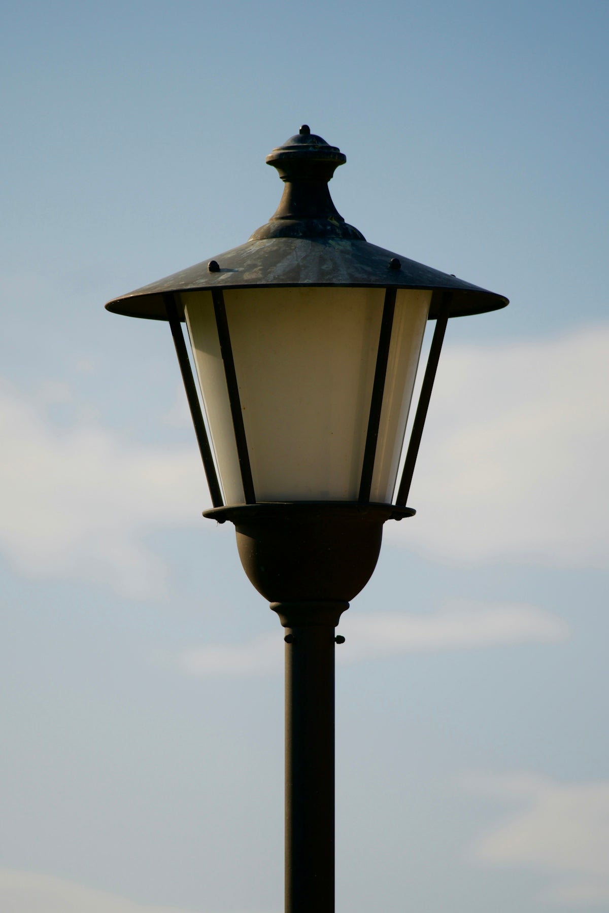 A lamp post with a blue sky in the background