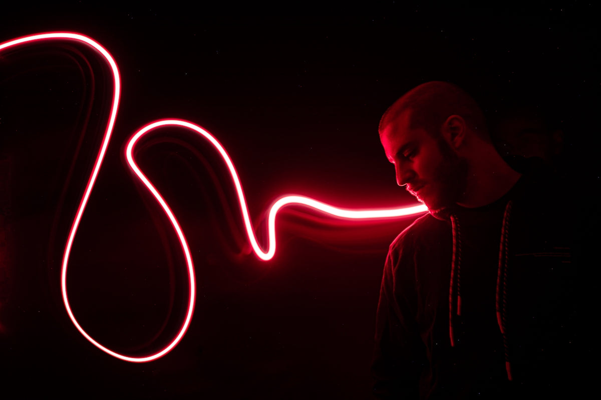 A man standing in the dark with a red light