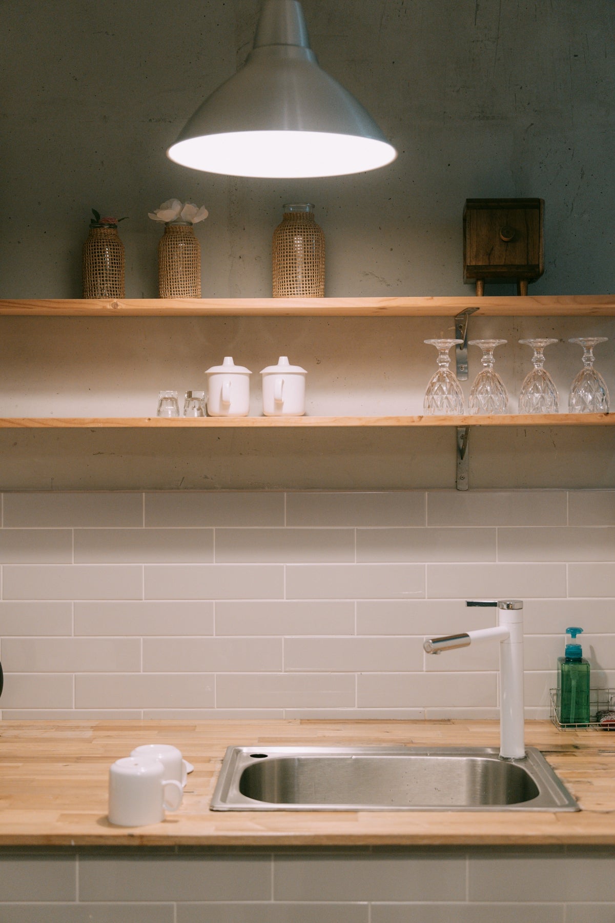 A kitchen counter with a sink and a light above it