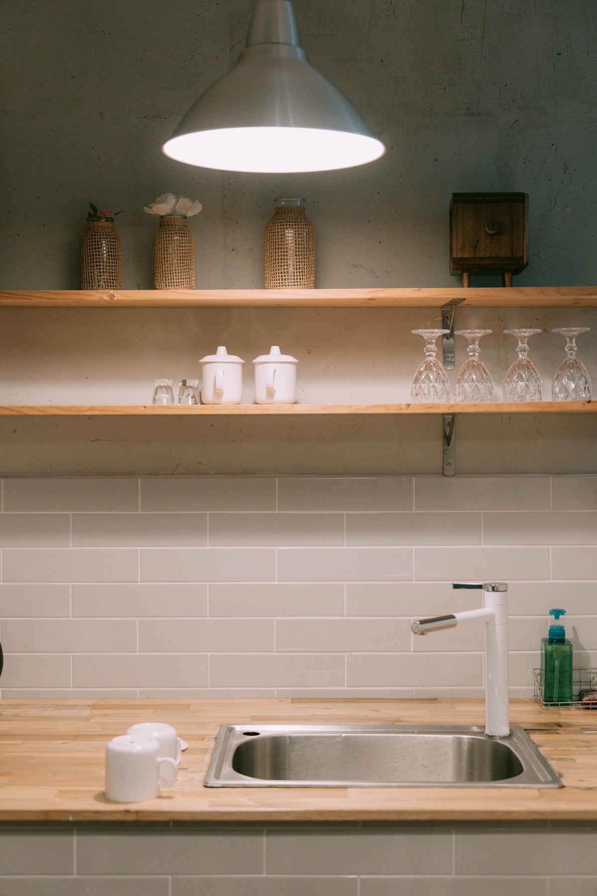 A kitchen counter with a sink and a light above it
