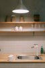 A kitchen counter with a sink and a light above it