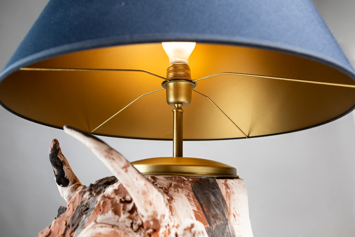 A table lamp with a blue shade on top of it