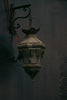 A lamp hanging from a wall in a dark room