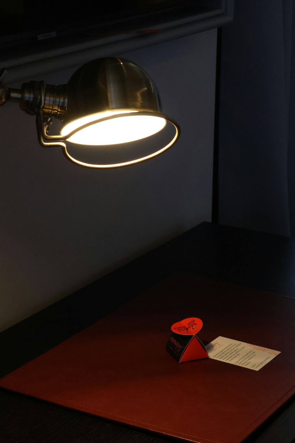 A desk with a lamp and a piece of paper on it