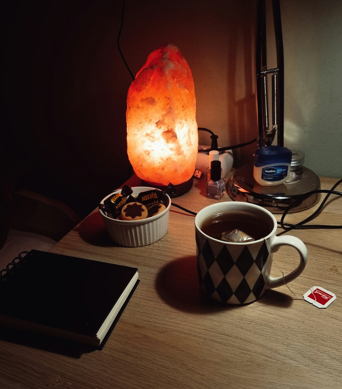 Cozy nighttime setup with tea and lamp.