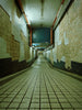 An eerie, tiled hallway with peeling walls.