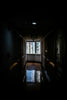 A dark hallway leads to a bright window.