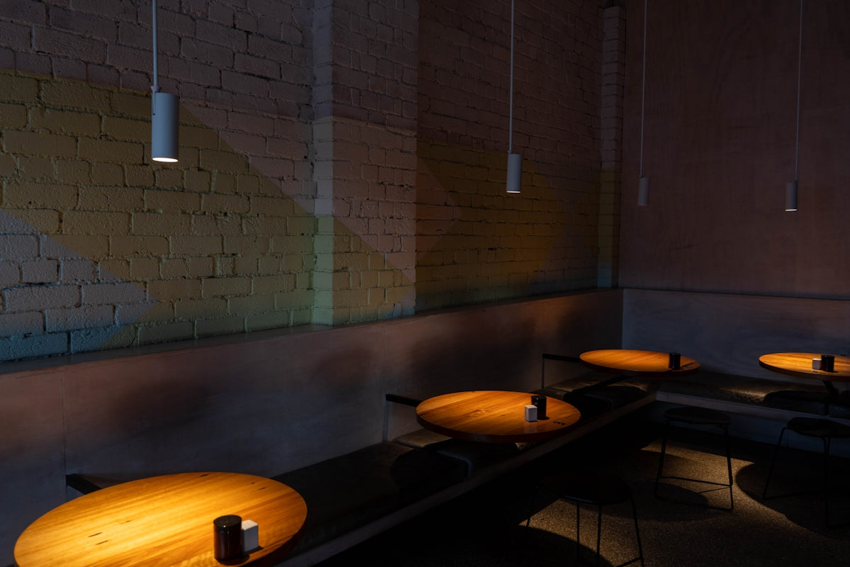 Restaurant tables lit by hanging lights.
