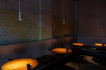 Restaurant tables lit by hanging lights.