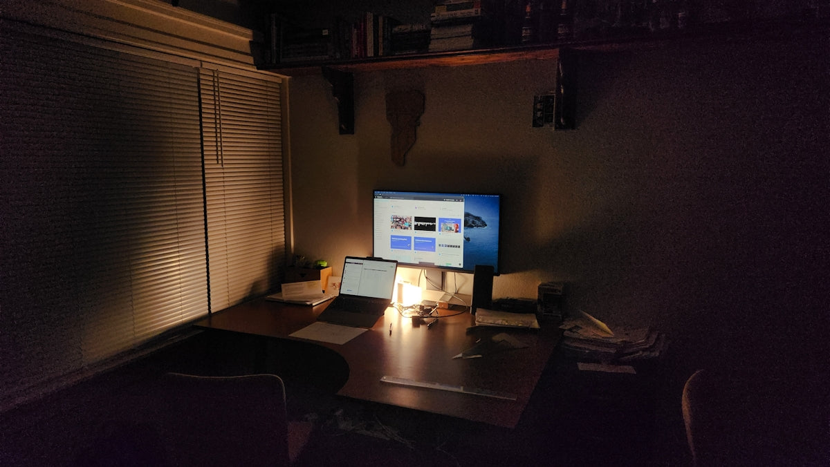 A dark office space with computer and desk.