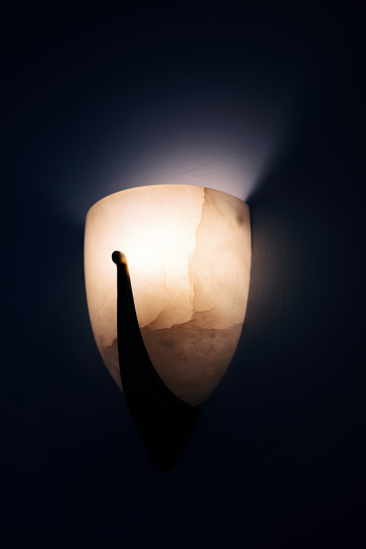 A lit wall sconce emits warm light.