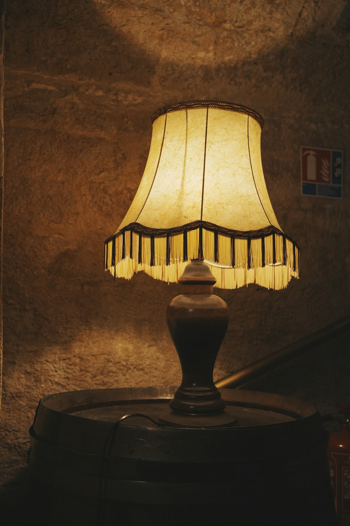 An illuminated lamp sits on a dark surface.