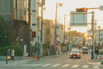 Street scene with cars and buildings at sunset.