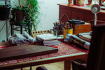 Art supplies and plants on a wooden desk.